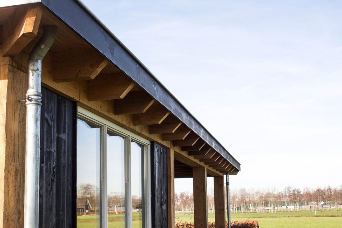 Zijgevel met schuifpui en doorlopende douglas overkapping